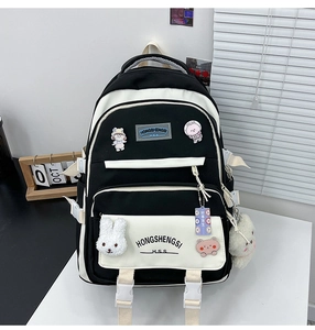 Detail of school backpack with cartoon badges and white plush rabbit pendant accessory