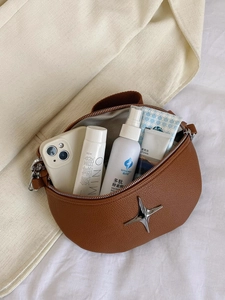 Internal storage of brown moon bag showing capacity for phone and cosmetics