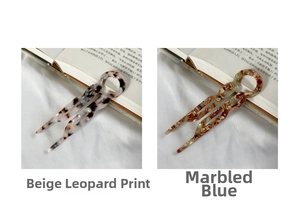 Detail of U-shaped acetate hair forks in beige leopard and colorful blue marble textures