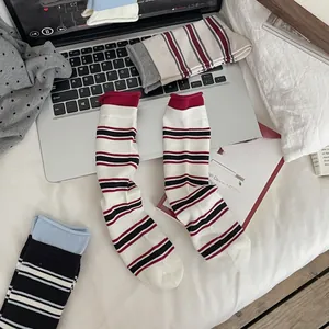 Detail of striped knitted crew socks showing contrasting ribbed cuffs and soft cotton texture