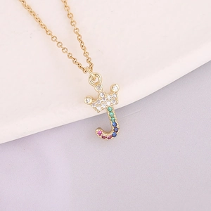 Macro view of gold J-letter crown pendant with colorful inlaid zircon gemstones
