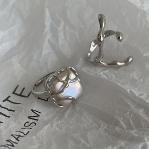 Close-up of minimalist silver rings featuring a baroque pearl in an irregular branch setting