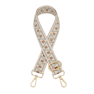 Detail of adjustable geometric ethnic woven bag strap with golden metal hardware