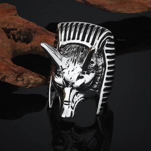 Détails sculptés d'une bague tête de loup Anubis sur surface réfléchissante noire et bois