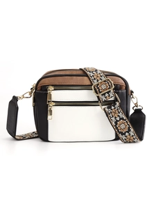 Detail view of cowhide-style PU crossbody bag with multi-zipper pockets and patterned strap