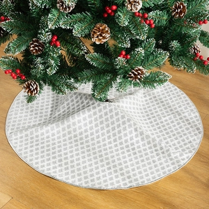 Gonna per albero di Natale tonda grigia e bianca con motivi geometrici su pavimento