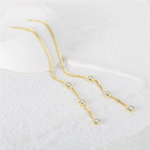 Detail of gold box chain earrings featuring three sparkling round white zircons