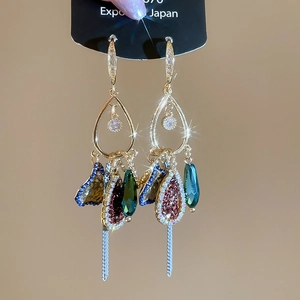 Detail of vintage bohemian drop earrings with multicolor crystals and long metal tassels