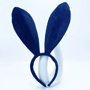 Detailed view of a dark blue plush bunny ears headband on a white curved display stand