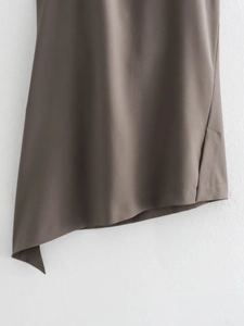 Detail of asymmetrical hemline and side slit on dark brown sleeveless set