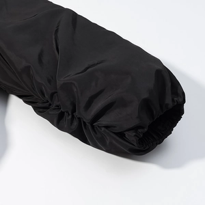 Detailed view of elastic ribbed cuffs on a black jacket with a subtle metallic sheen