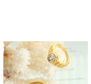 Detailed macro shot of a gold ribbed ring featuring a brilliant round cut zircon gemstone