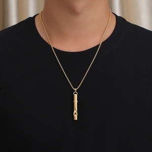 Polished gold whistle pendant necklace styled on a black shirt for a minimalist look
