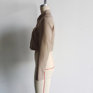 Detail of khaki cotton linen jacket with utility pockets on a white background