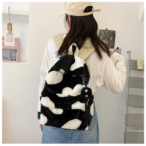 Detail of plush black and white faux fur backpack with cute furry eyeball charm on back