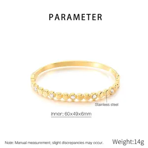 Détail du bracelet en acier inoxydable doré avec motifs de cylindre et oxydes de zirconium