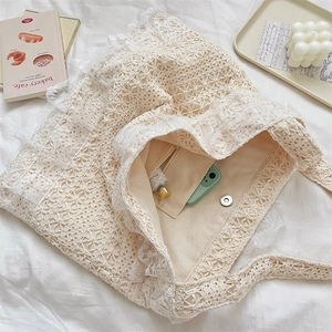 Close-up of lace tote bag with crochet floral patterns, canvas lining and magnetic buckle