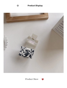 Close-up of marble and translucent rectangular hair claws with metal spring detail