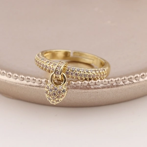 Detailed macro view of a gold-plated heart pendant ring with sparkling white zircons