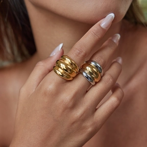 Close-up of chunky ribbed two-tone 18k gold plated stainless steel ring on model finger