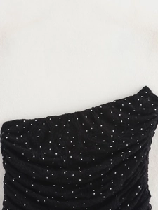 Gros plan sur un tissu en maille noire orné de paillettes argentées et détails brillants
