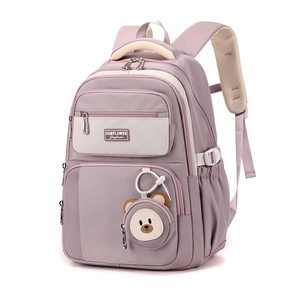 Detail view of large capacity purple school backpack with ergonomic straps and bear charm