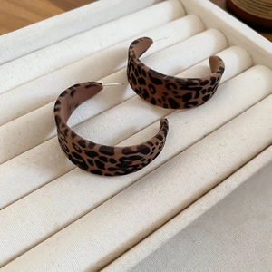 Gros plan détaillé de boucles d'oreilles en C à motif léopard avec texture velours mat
