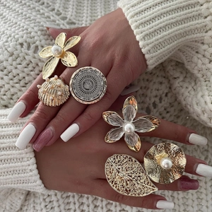 Bohemian gold ring set with pearls featuring floral and leaf motifs on model hand