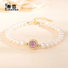 Macro shot of s925 silver pearl bracelet with central purple gemstone and gold clasp