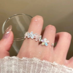Detail of adjustable open ring with colorful enamel flowers on model finger