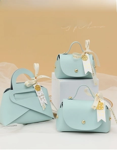Detail of light blue faux leather gift box with gold hardware and white silk ribbons