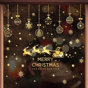 Golden Christmas window stickers featuring Santa's sleigh, snowflakes, and festive balls