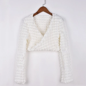 Detailed close-up of white bubble-textured crop top with cross V-neck and long sleeves