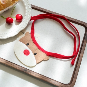 Detail view of a reindeer pet bandana in felt material with red ties for dogs