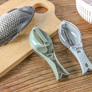 Fish scaler tool with lid in green and grey colors on a wooden kitchen table