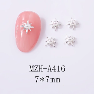 Macro shot of silver starburst nail charms with center pearls and 7x7mm sizing
