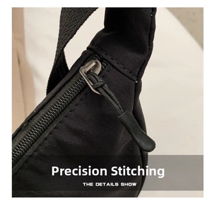 Detailed close-up of smooth zipper pull and reinforced stitching on black nylon bag