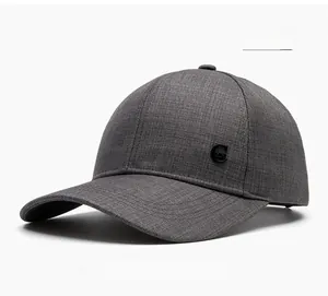 Detail of grey twill baseball cap with metallic letter emblem and textured fabric