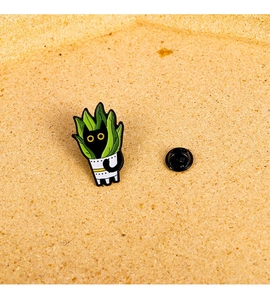 Detailed view of an enamel black cat hiding in a green potted plant lapel pin
