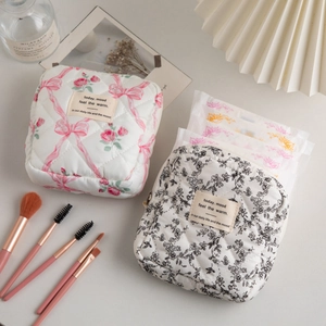 Detail of quilted cotton makeup bag showing floral patterns and smooth zipper closure
