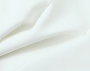 Close-up of premium white textile fabric showing soft drape and fine knitted texture