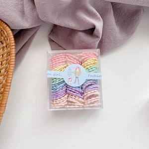 Flat lay of colorful candy-colored kids elastic hair ties in a clear plastic gift box