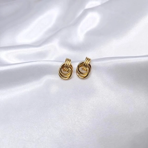 Chic gold-tone multi-layered intertwined loop earrings on white silk background