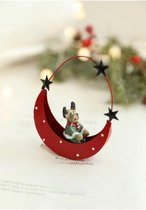 Close-up of a festive red moon base and green reindeer iron ornament with Christmas bokeh