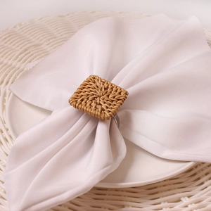 Close-up of square rattan napkin ring in natural brown on a white dining table set