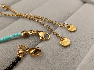 Detail of stainless steel lobster clasp and extension chain with S.steel logo tag