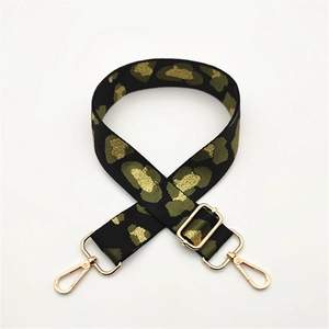 Detail of leopard print bag strap with gold metal hardware and adjustable buckles