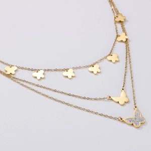 Detail of layered gold butterfly necklace with crystal pendant on stainless steel chain