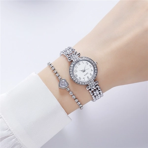 Close-up of silver quartz watch and heart bracelet with diamonds on woman's wrist