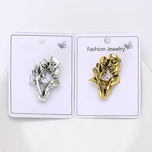 Close-up of gold and silver lover kiss pins on display cards for garment styling